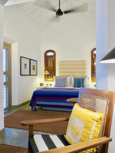 a bedroom with a bed and a chair in it at Samaragiri in Talpe