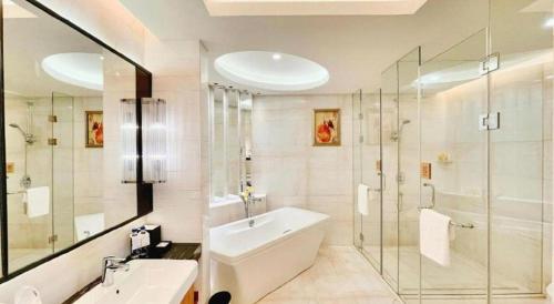 a bathroom with a tub and a sink and a shower at Grand Soluxe Zhongyou Hotel Shenzhen in Shenzhen