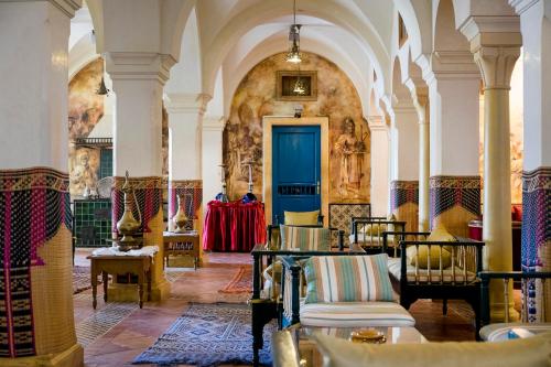 a large room with a blue door and chairs at Medina Belisaire And Thalasso in Hammamet