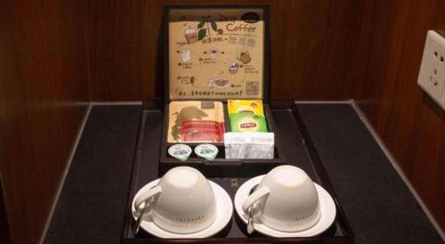 a tea set with two cups and spoons on a table at James Joyce Coffetel Xian Dayanta Metro Station Branch in Xi'an