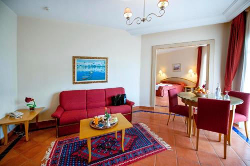 a living room with a red couch and a dining room at Medina Belisaire And Thalasso in Hammamet