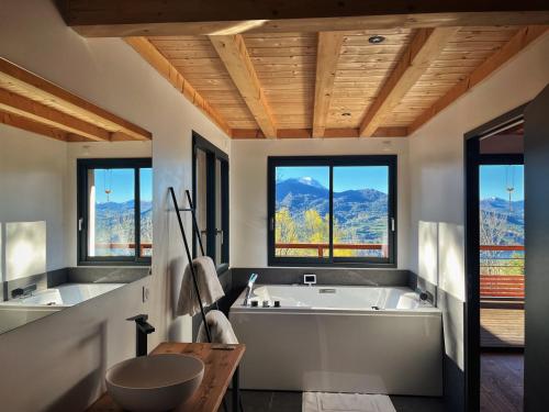 a large bathroom with a tub and two windows at Les balcons de saint Apollinaire in Saint-Apollinaire