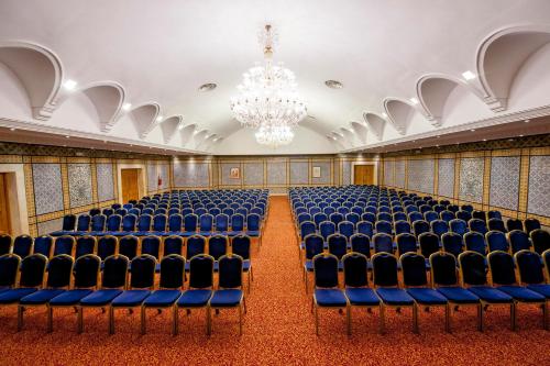 an empty room with blue chairs and a chandelier at Medina Belisaire And Thalasso in Hammamet