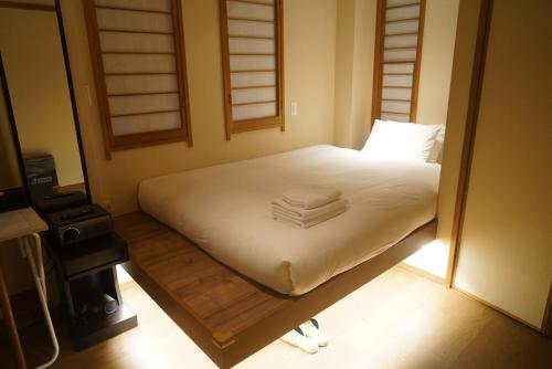 a bedroom with a bed with towels on it at Softlight Inn Asakusa Tokyo in Tokyo
