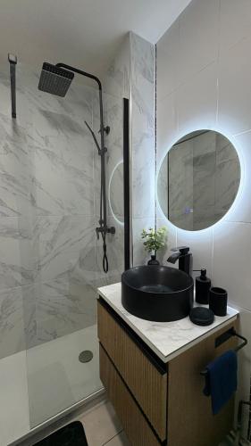 une salle de bain avec un lavabo et une douche dans l'établissement Le Studio Marquis, Évry-Courcouronnes