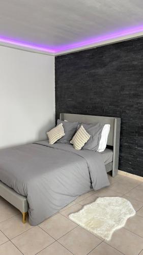 - une chambre avec un grand lit et un plafond violet dans l'établissement Le Studio Marquis, Évry-Courcouronnes