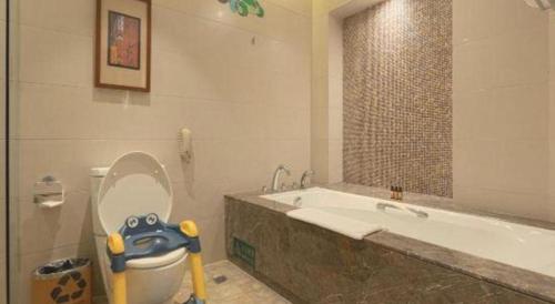a bathroom with a toilet and a bathtub with a toy at Wuhan Gleetour Hotel in Wuhan