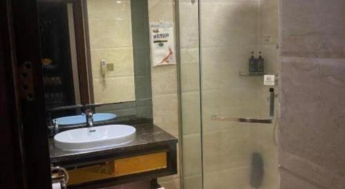 a bathroom with a sink and a glass shower at Chengdu Haotian Guotai Hotel in Chengdu