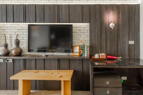 a living room with a television and a desk with a table at 白水木民宿 in Eluan