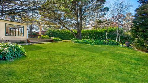 a yard with green grass and a house at Glenluce Mountain Cottage Circa 1896 in Wentworth Falls