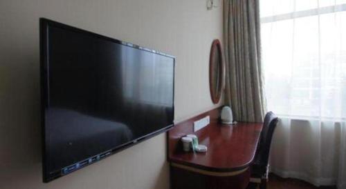 a large flat screen tv hanging on a wall at GreenTree Inn Shanghai Hongqiao Airport Huqingping Highway Shell Hotel in Shanghai