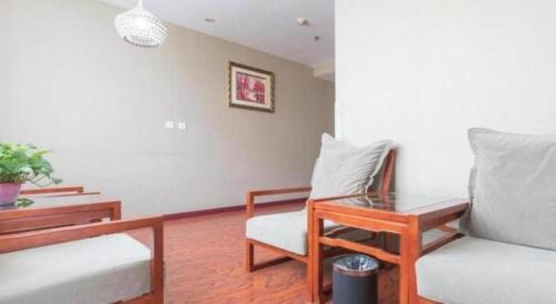 a living room with a couch and a table and a chair at GreenTree Inn Taiyuan PinGYAng Road Business Hotel in Taiyuan