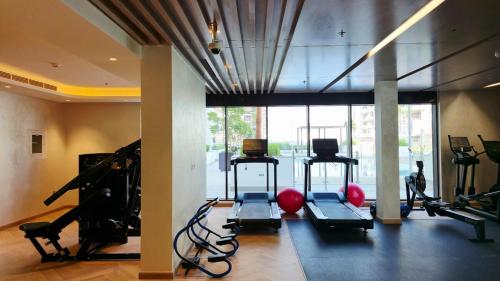 a gym with several treadmills and exercise bikes at Stylish Studio in Dubai in Dubai