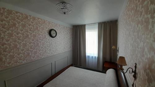 a room with a window and a clock on the wall at Järve Apartment in Kohtla-Järve