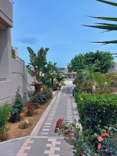 a walkway with flowers and plants on the side of a building at Gelina Apartments in Plataniás