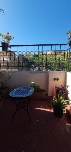a patio with a blue table and a fence at ESC Apartments in Fès