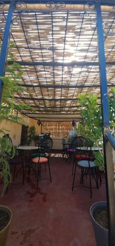a patio with tables and chairs under a roof at ESC Apartments in Fès