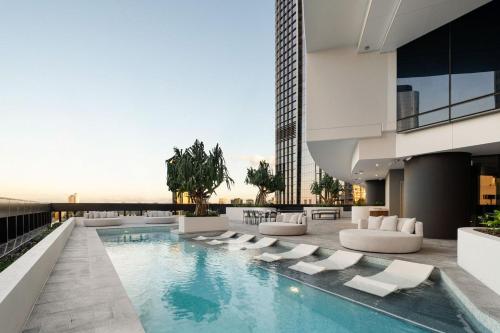 a swimming pool with lounge chairs and a building at Queens Wharf Diamond Level 60, Sleep 5, 1 carpark in Brisbane