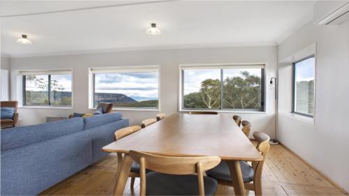 comedor con mesa y sofá azul en Bella Vista Valley Views, en Blackheath