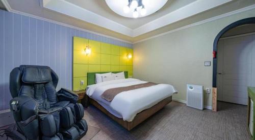 a bedroom with a bed and a chair in it at Luxury Motel Daejeon in Daejeon