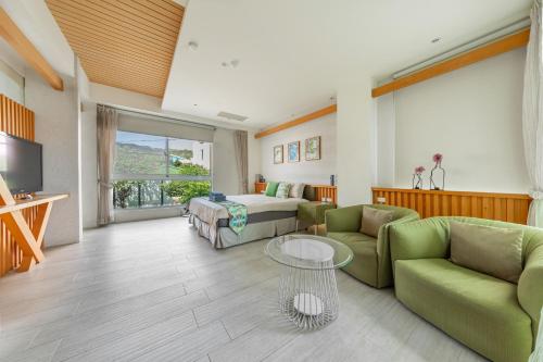 a living room with a bed and a couch and a table at 白水木民宿 in Eluan