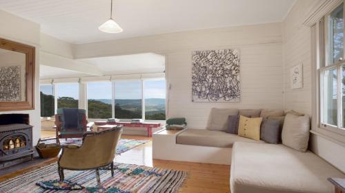 a living room with a couch and a fireplace at Cecils Chair Blackheath Blue Mountains in Blackheath