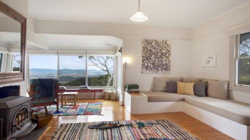 a living room with a couch and a fireplace at Cecils Chair Blackheath Blue Mountains in Blackheath