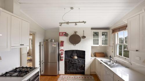 a kitchen with a refrigerator and a stove top oven at Cecils Chair Blackheath Blue Mountains in Blackheath