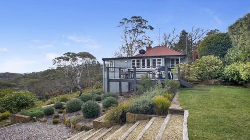 a house in the middle of a garden at Cecils Chair Blackheath Blue Mountains in Blackheath