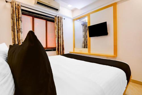 a bedroom with a white bed and a window at Super Collection O Andheri West Near KokilaBen Hospital in Mumbai
