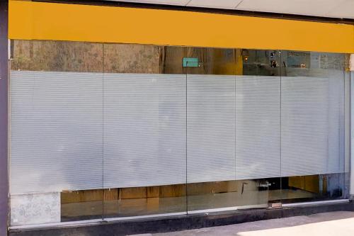 a glass wall with blinds on a building at Super Collection O Andheri West Near KokilaBen Hospital in Mumbai