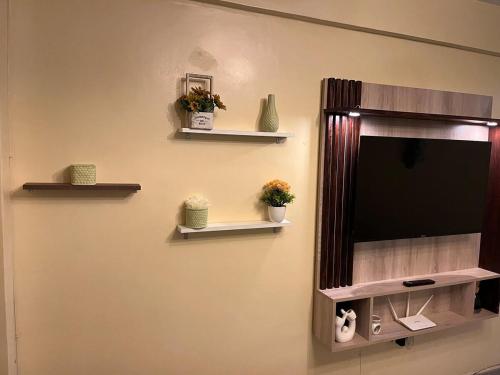 a television on a wall with shelves on it at Luxury-Inn Apartment in Nyeri
