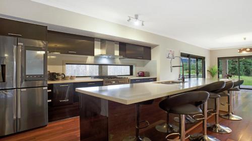 Una cocina con una gran isla con taburetes de bar. en The Cherry Blossom Blackheath, en Blackheath