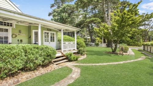 a green house with a porch and a yard at Quinees Charming Mountain Cottage in Blackheath