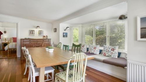 a dining room with a table and a couch at Quinees Charming Mountain Cottage in Blackheath