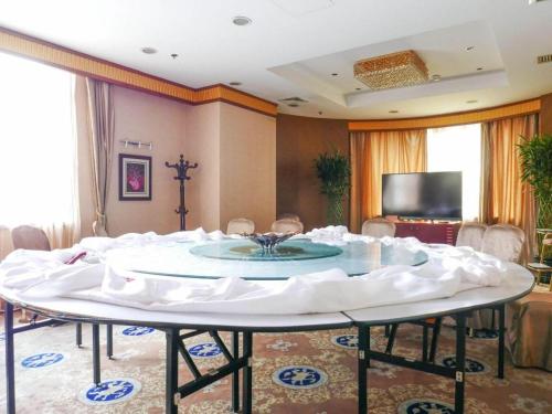a large white table in a room with chairs at Shaanxi Business Hotel in Shanghai