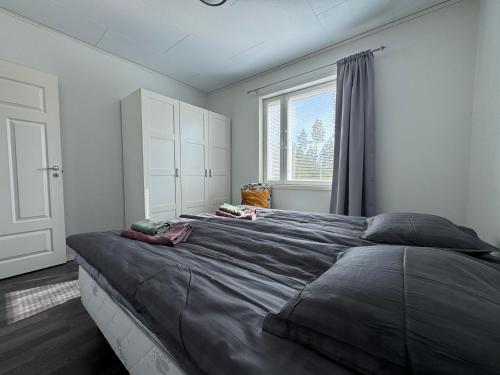 a large bed in a bedroom with a window at Anolanranta Beach House - Golf & Lake in Pieksamaki
