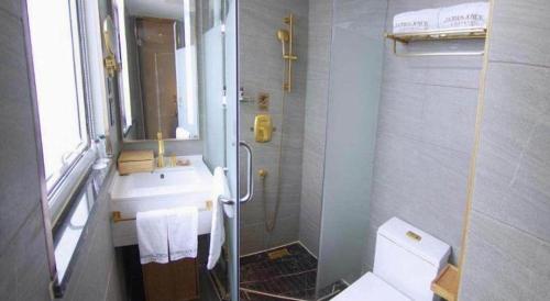 a bathroom with a sink and a toilet and a mirror at James Joyce Coffetel Beijing Yizhuang Rongjing East Street Subway Station in Beijing