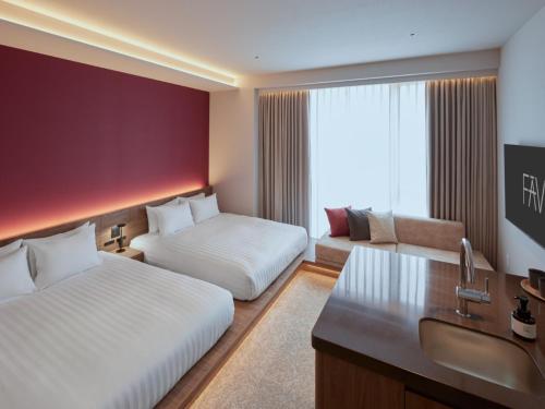 a hotel room with two beds and a desk at FAV LUX Sapporo Susukino in Sapporo