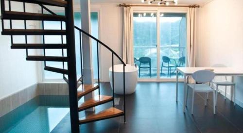 a spiral staircase in a room with a table and chairs at All That Water Pension in Gapyeong