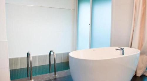 a bathroom with a white tub and a mirror at All That Water Pension in Gapyeong
