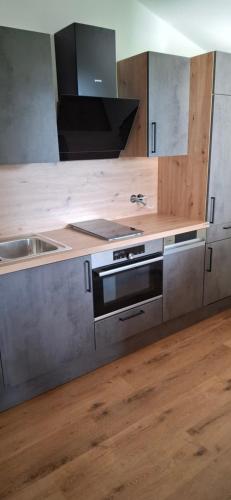 eine Küche mit einem Edelstahlherd und einer Spüle in der Unterkunft Ferienhaus Strasser in Ramsau am Dachstein