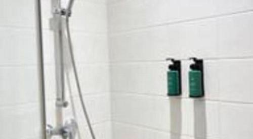 two green shampoo bottles sitting on a shelf in a bathroom at Tematik Hotel Pluit in Jakarta