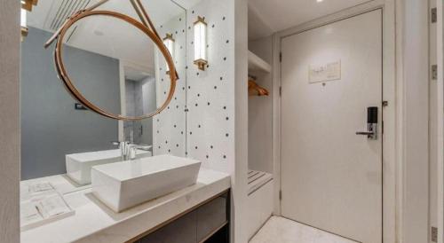 a white bathroom with a sink and a mirror at Jinjiang Metropolo Hotel Nanjing Confucius Temple Branch in Nanjing