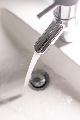 a sink with water coming out of a faucet at Villa ENTO HotelWestEnd in Frankfurt/Main