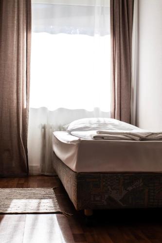 a bed sitting in a room with a window at Villa ENTO HotelWestEnd in Frankfurt/Main