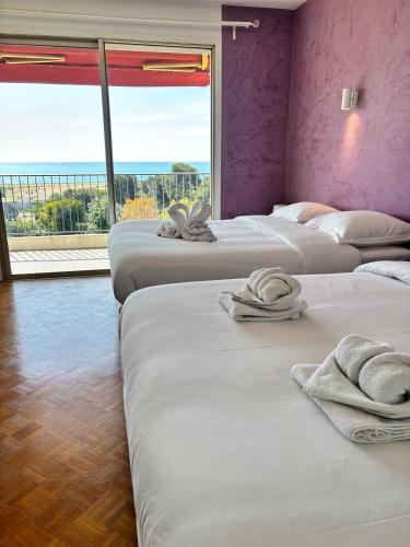 - une chambre avec 4 lits et des serviettes dans l'établissement Splendid T6 Panoramic sea view Free Parking, à Cagnes-sur-Mer