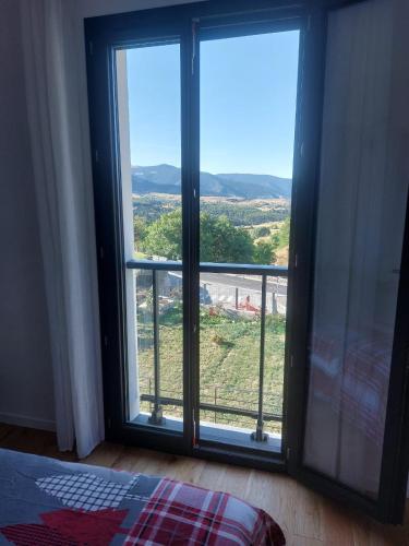 a room with a large window with a view at Maison de vacances à la montagne avec vue panoramique in Bolquere Pyrenees 2000