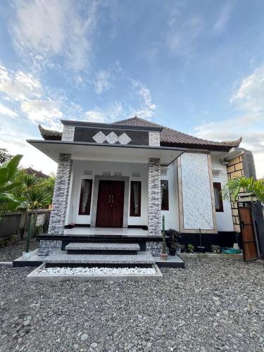 a small white house with a driveway at Alca House in Airsatang