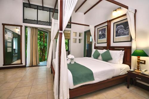 a bedroom with a bed with a canopy at Reen Resorts Aanavilasam Plantation Thekkady in Thekkady